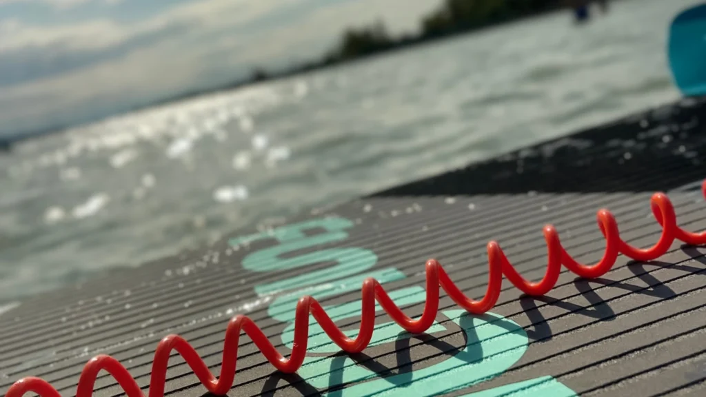 Család vagy pár SUP deszkával a Balaton partján, háttérben a Hotel Csopak épülete Balaton szállás 4 éjszakára SUP bérlés Hotel Csopak